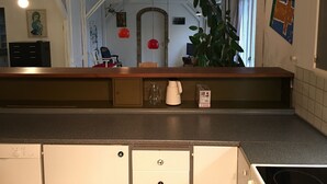 Ett kök med en bänkskiva i trä, en kaffebryggare från Bosch och ett vitt skåp.