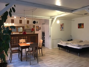Ein kompakter Wohnraum mit Essbereich, einem Bett und einer Küchenzeile.