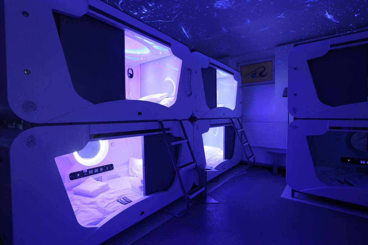A room with multiple beds, each with a built-in screen displaying a circular interface.