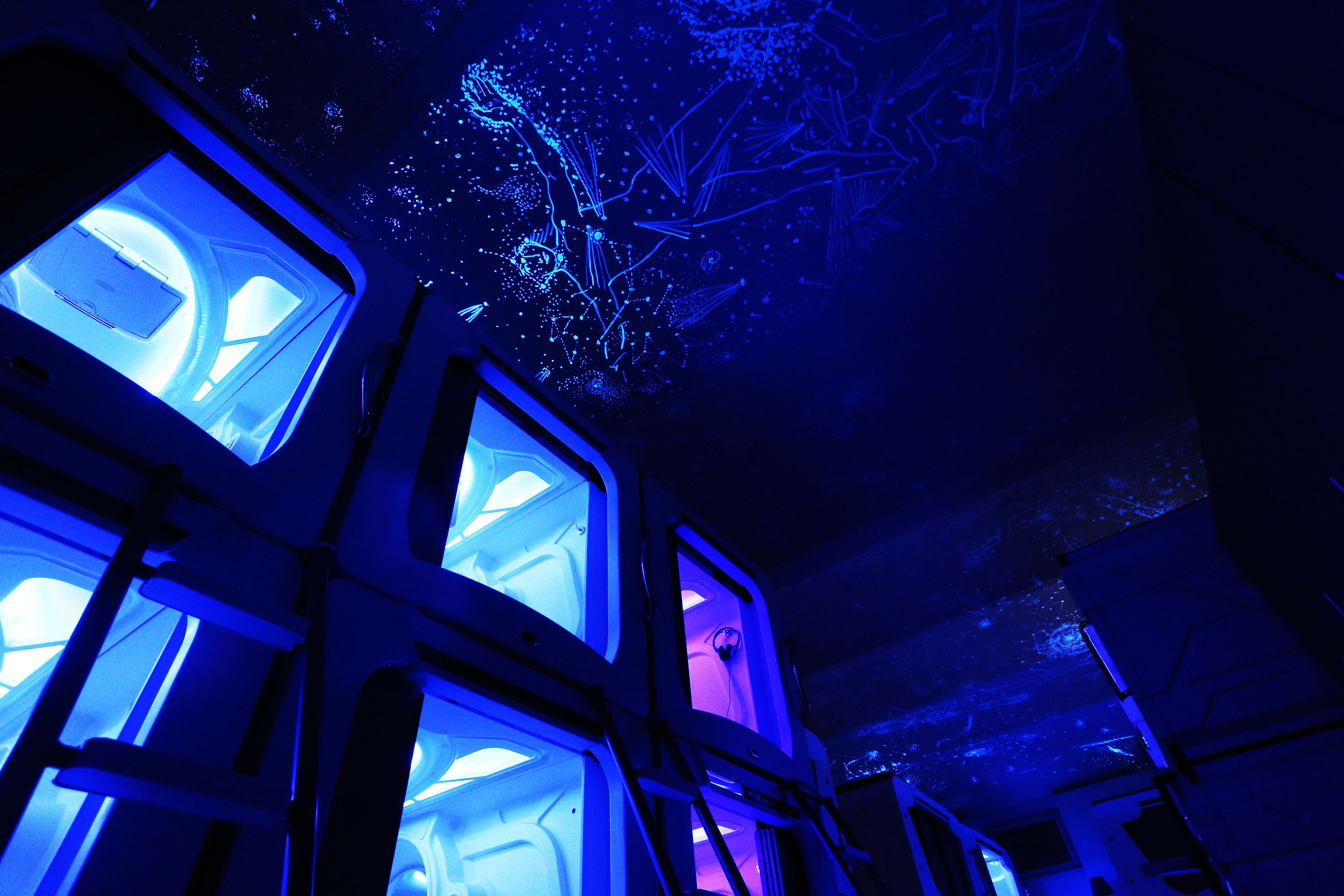 Una habitación con varias ventanas, cada una con vista al cielo estrellado.
