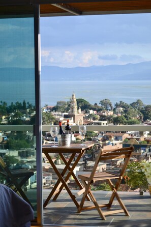 A balcony with a table, two chairs, a wine bottle, and a glass. - Donaire Hotel Boutique (Ajijic)