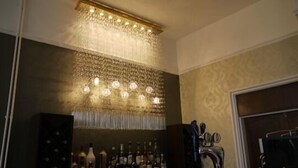 A bar area with a patterned ceiling and wall, and a row of bottles on the counter. - Hillcrest Hotel (Lincoln)