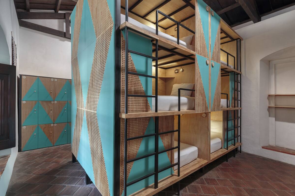 Un lit superposé à plusieurs niveaux, doté d’un design géométrique, d’une structure en bois et d’un dossier tissé.