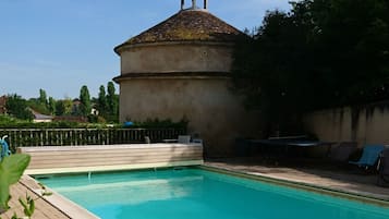 Una piscina al aire libre de temporada, sillones reclinables de piscina