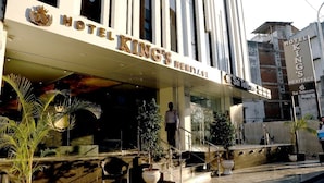 Exterior do Hotel King's Heritage, com uma entrada notável, uma escadaria que leva ao saguão e um letreiro da Sai Telecom.