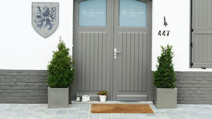 A grey double door with the text "La Garonde" on the glass panels, a shield emblem on the wall, and the number "447" to the right. - La Garonde (Berthen)