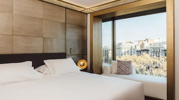 Une chambre d’hôtel moderne dotée d’un grand lit, d’un canapé, d’une vue sur la ville et d’une grande fenêtre.