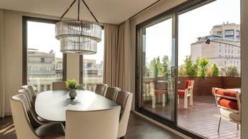 A modern dining area with a round table, chairs, and a hanging light fixture.