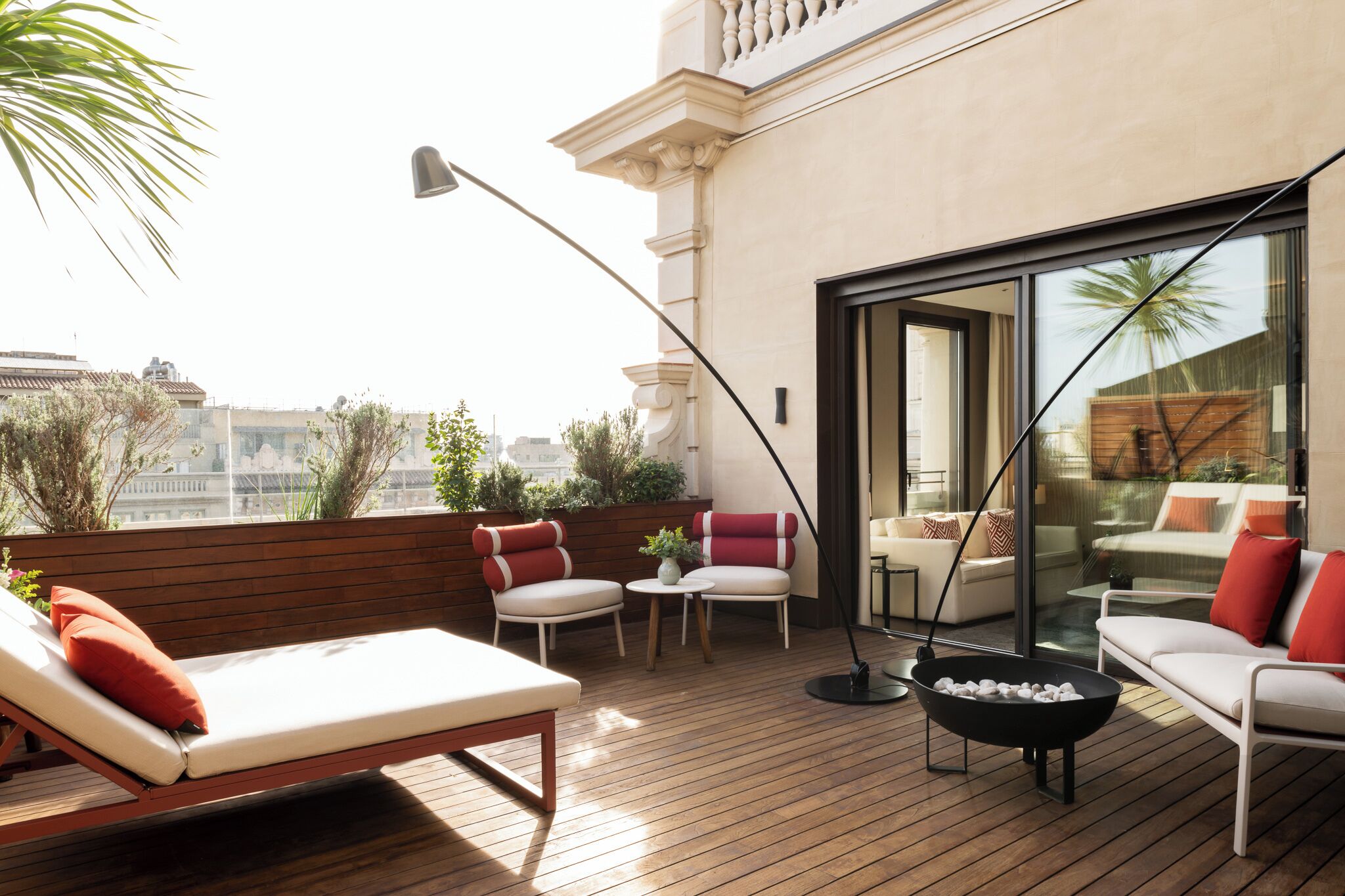 A rooftop terrace with a lounge area, seating, and a fire pit.