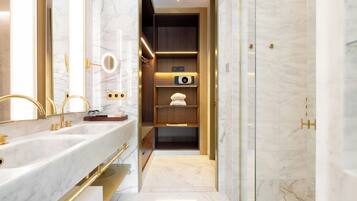 Une salle de bain moderne dotée d’un meuble-lavabo à deux vasques, d’une douche à l’italienne et d’étagères intégrées, ainsi que d’un miroir et d’un porte-serviettes.