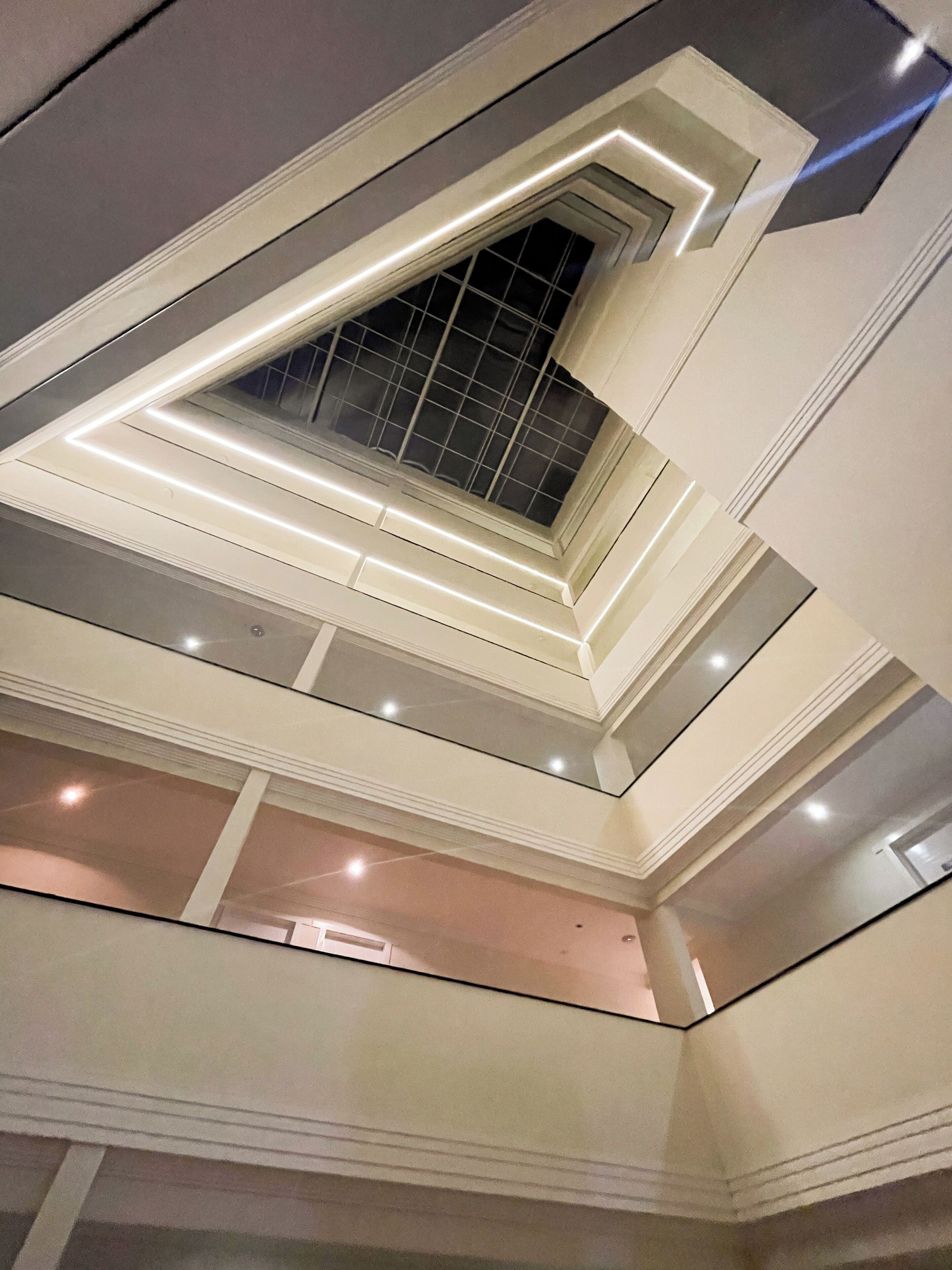 Un interno moderno con lucernario, illuminazione a incasso e un design pulito e geometrico.