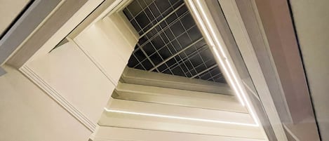 A modern interior with a sloped ceiling and recessed lighting.