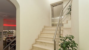 A staircase with a metal railing leading to an elevator. - Universo Romântico Guesthouse & Spa (Lisbon)