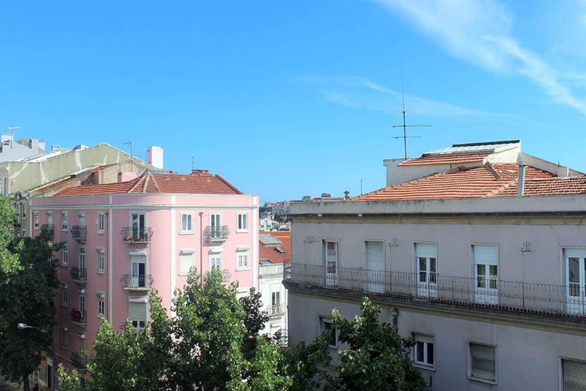 Una hilera de edificios de varios pisos con balcones y un cielo azul despejado.