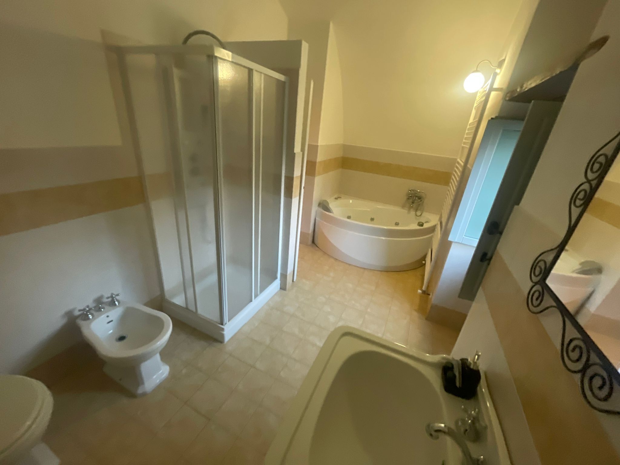 Un baño con ducha, bidé, bañera y lavamanos.