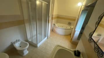Un baño con ducha, bidé, bañera y lavamanos.