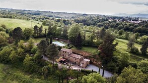 A rustic villa with a swimming pool, surrounded by lush greenery and hills. - Agriturismo Il Sentiero (Acquapendente)