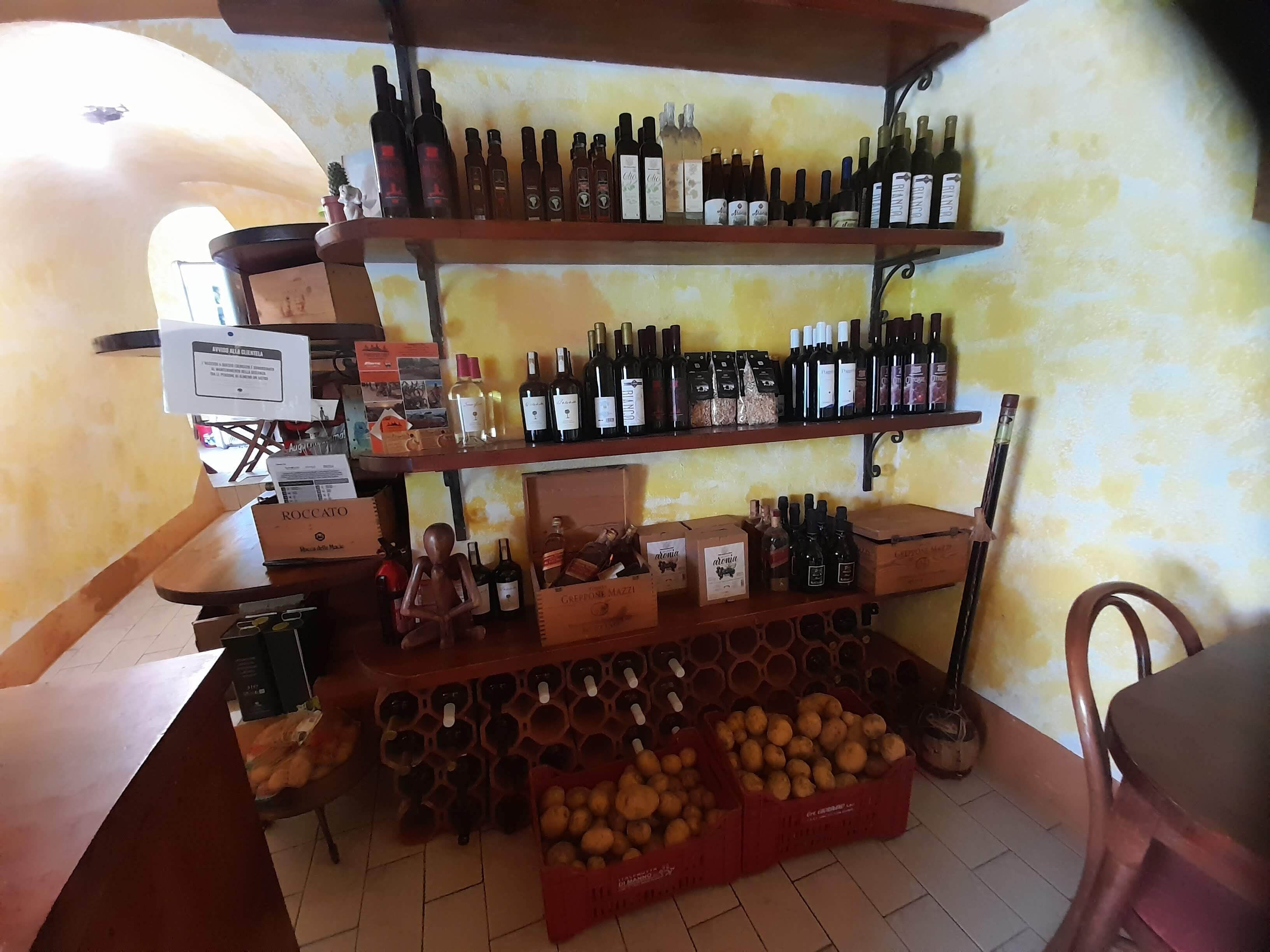 A wine shop with shelves of wine bottles and boxes of wine glasses.