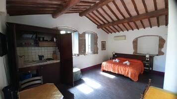 Un dormitorio con cama, cabecera de madera, mesita de noche, espejo y ventana.