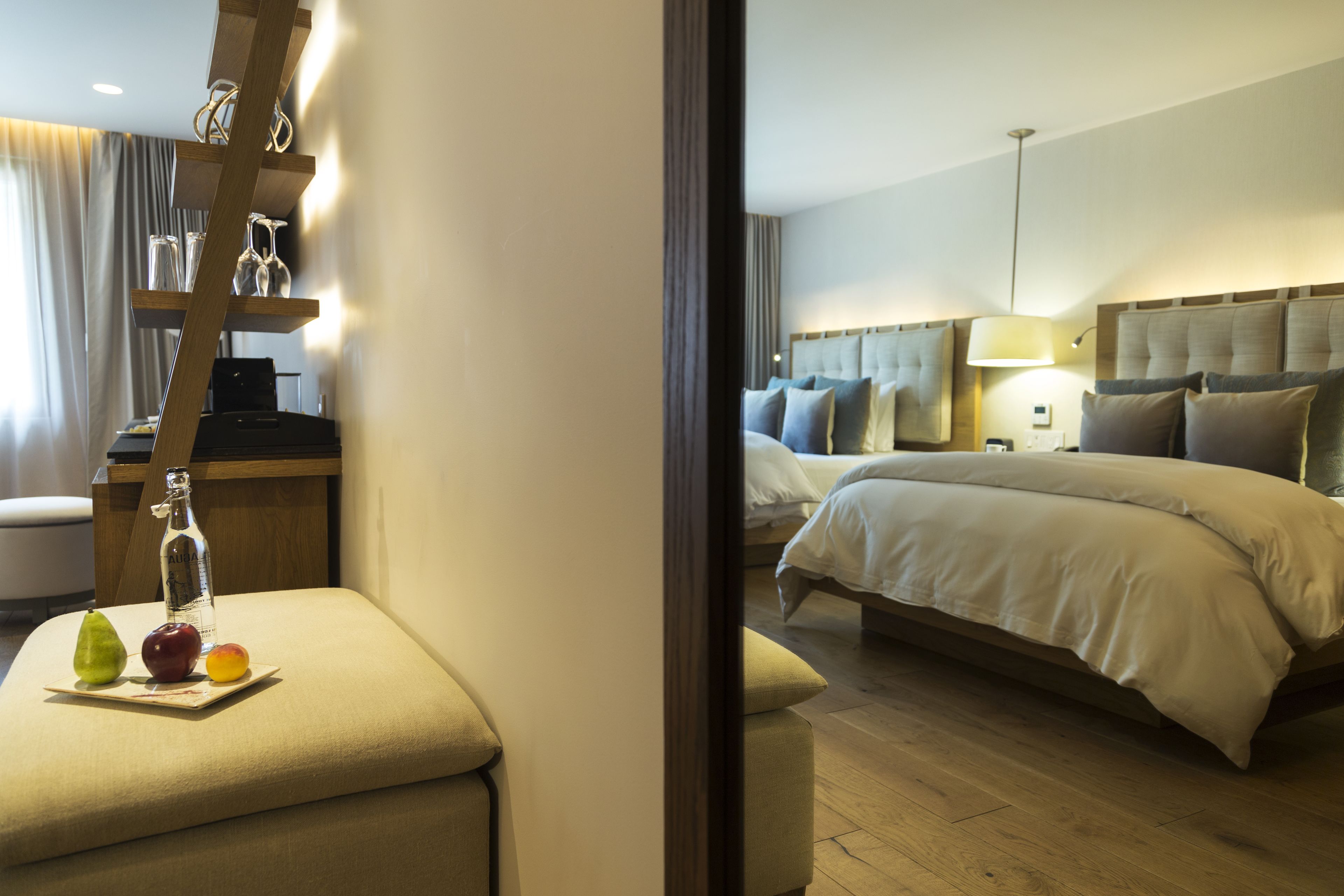 A hotel room with a bed, bedside table, and a small seating area with a table and chairs.