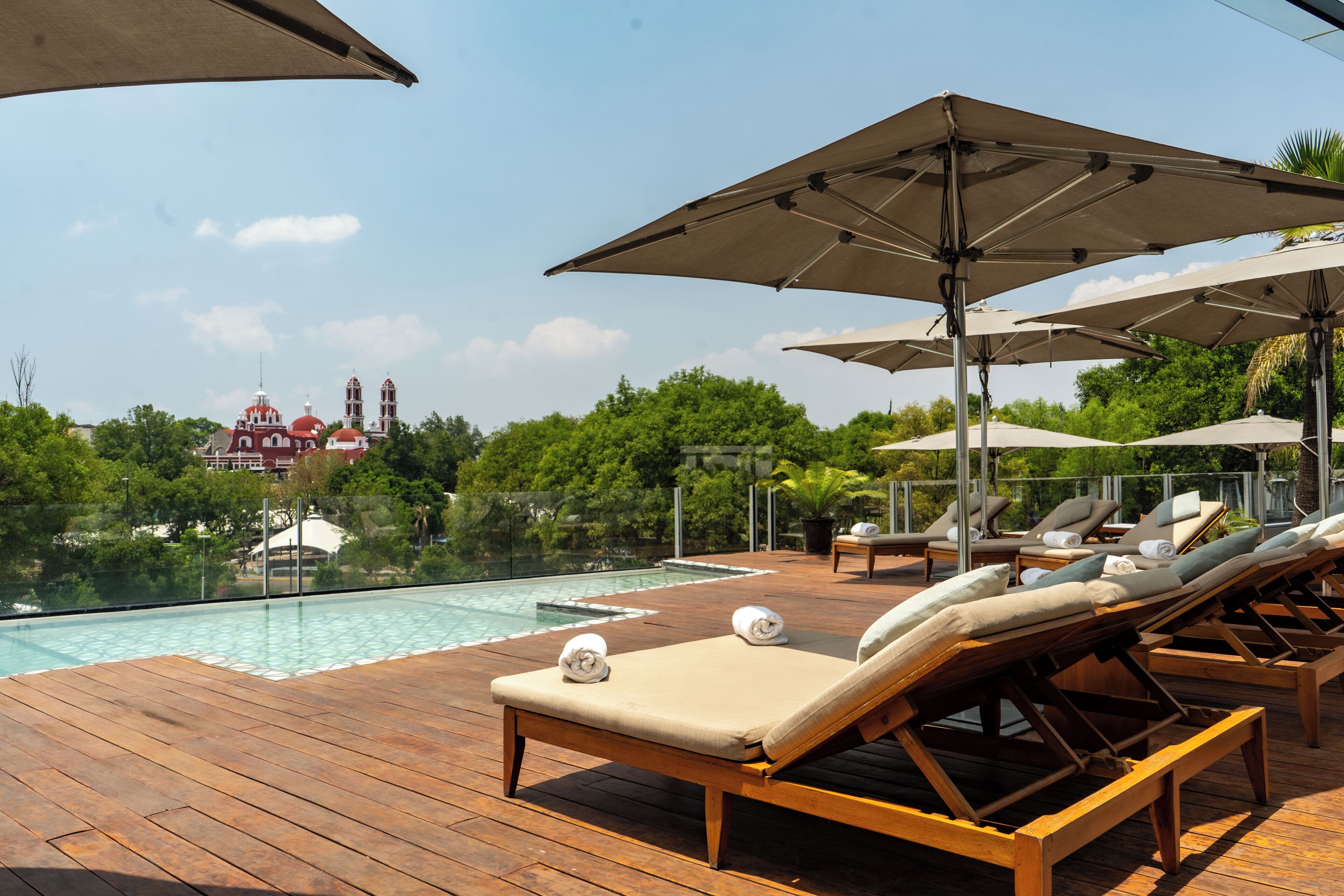 Alberca al aire libre, sombrillas en la alberca y camastros 