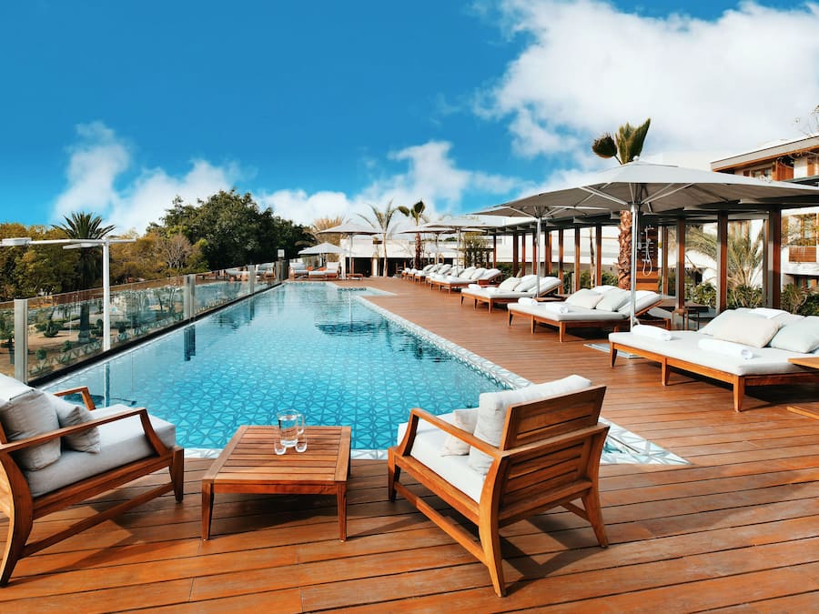 Een buitenzwembad, parasols voor strand/zwembad