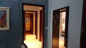 Een gang met een deur naar een badkamer en een slaapkamer.