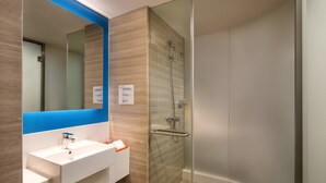 A modern bathroom with a glass-enclosed shower, a white sink with a blue accent, and a mirror with a blue frame. - Holiday Inn Express Wuxi Taihu New City by IHG (Wuxi)