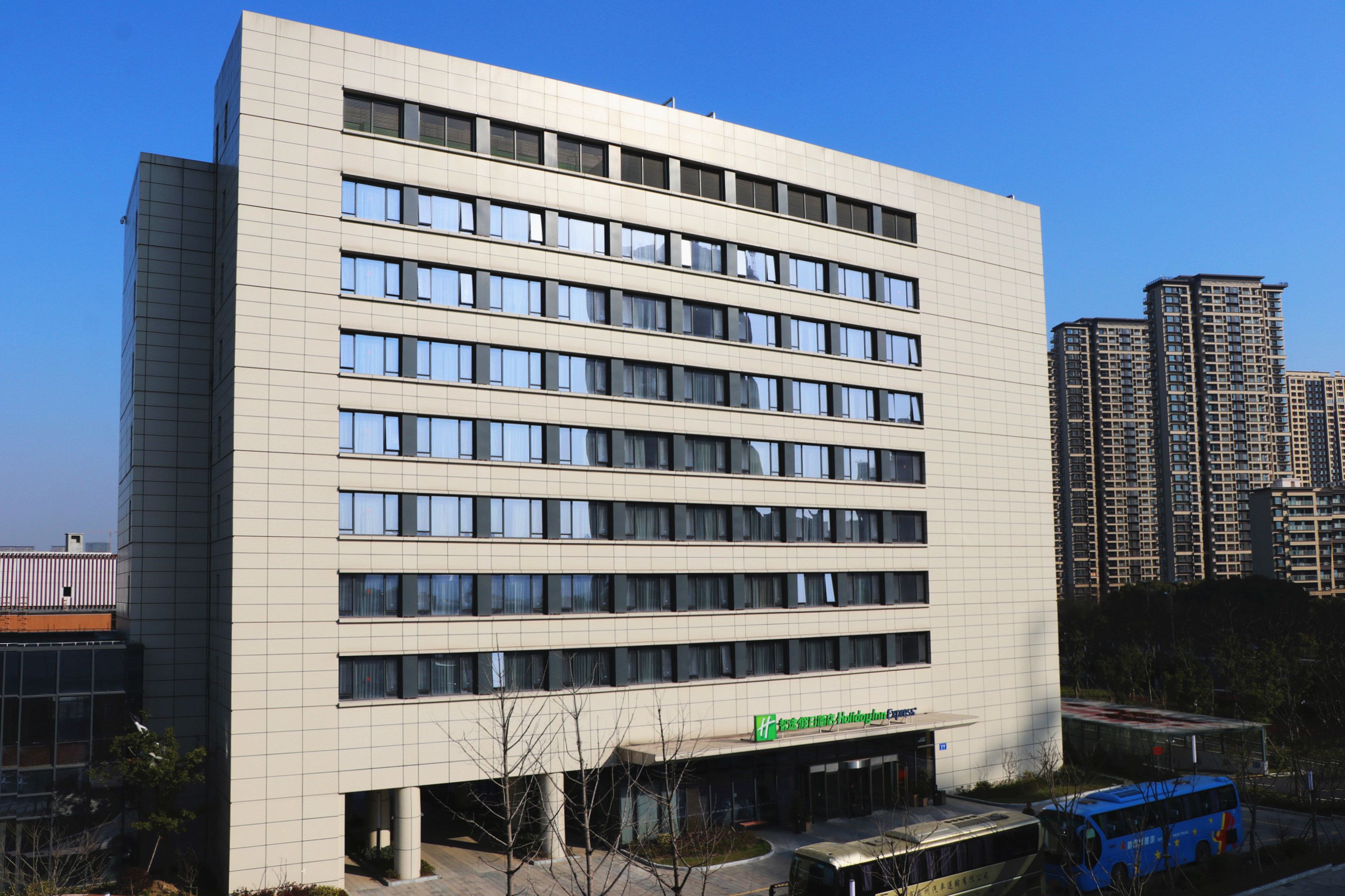A modern building with multiple floors, large windows, and a flat roof.