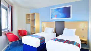 A hotel room with two beds, a red chair, a wooden shelf, and a painting on the wall.