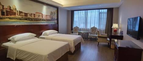 A hotel room with two beds, a sofa, a TV, and a painting of a cityscape on the wall.