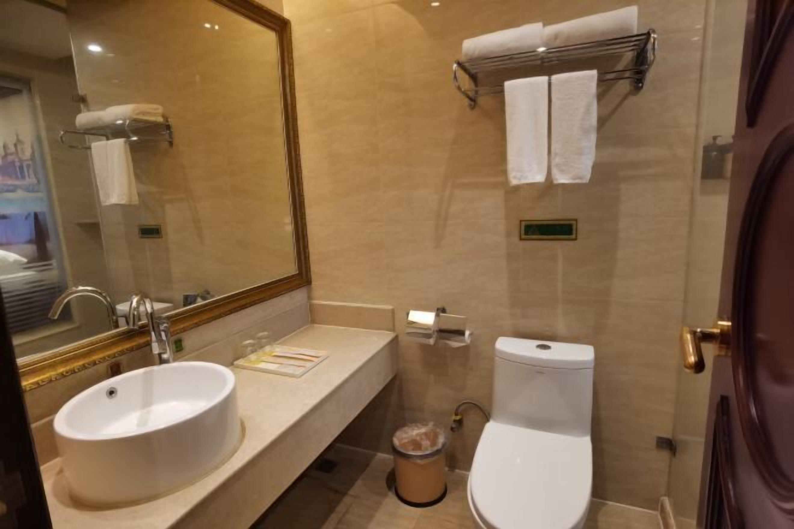 Een badkamer met een wastafel, toilet en een handdoekhouder.