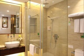 A modern bathroom with a glass-enclosed shower, a sink, and a toilet. - Vienna Hotel (Sanya Bay) (Sanya)