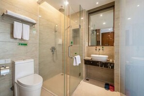 A modern bathroom with a glass-enclosed shower, a toilet, a sink, and a mirror. - Vienna Hotel (Sanya Bay) (Sanya)
