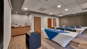 A conference room with long tables, a kitchenette, and a reception desk.