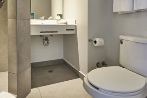 Un baño moderno con inodoro, lavamanos y ducha.