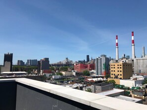A cityscape with industrial buildings, including two prominent smokestacks. - Hotel Nirvana (Long Island City)