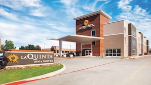 Edificio de La Quinta Inn & Suites, cielo despejado y estacionamiento.