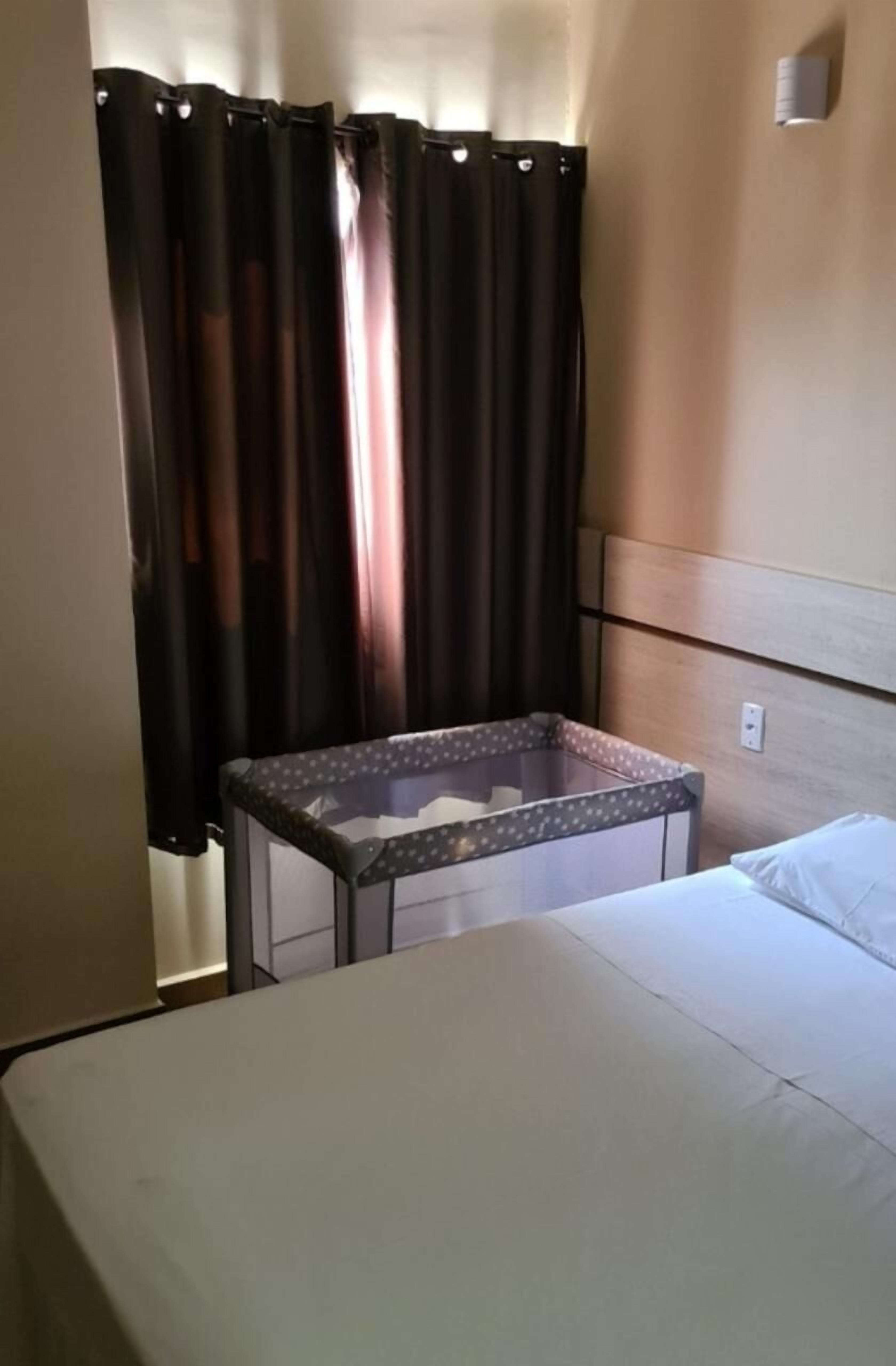 Ein Hotelzimmer mit einem Bett, einem kleinen Tisch und einem Vorhang.