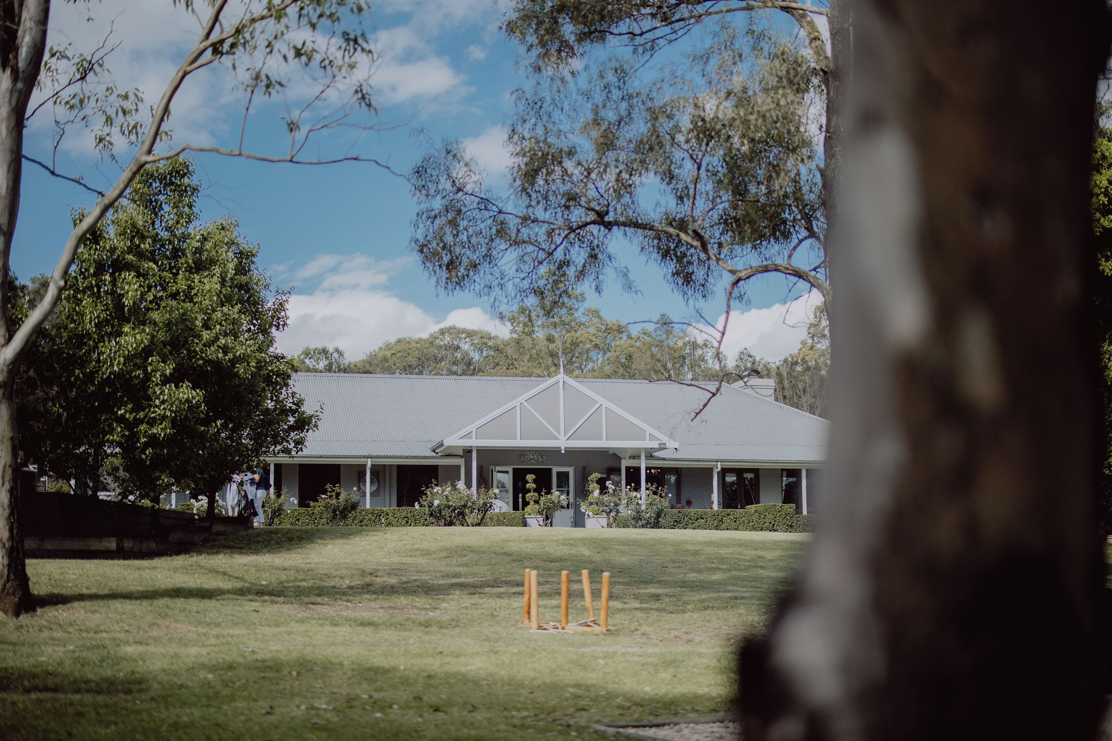 A building with a symmetrical roof and a covered porch area.