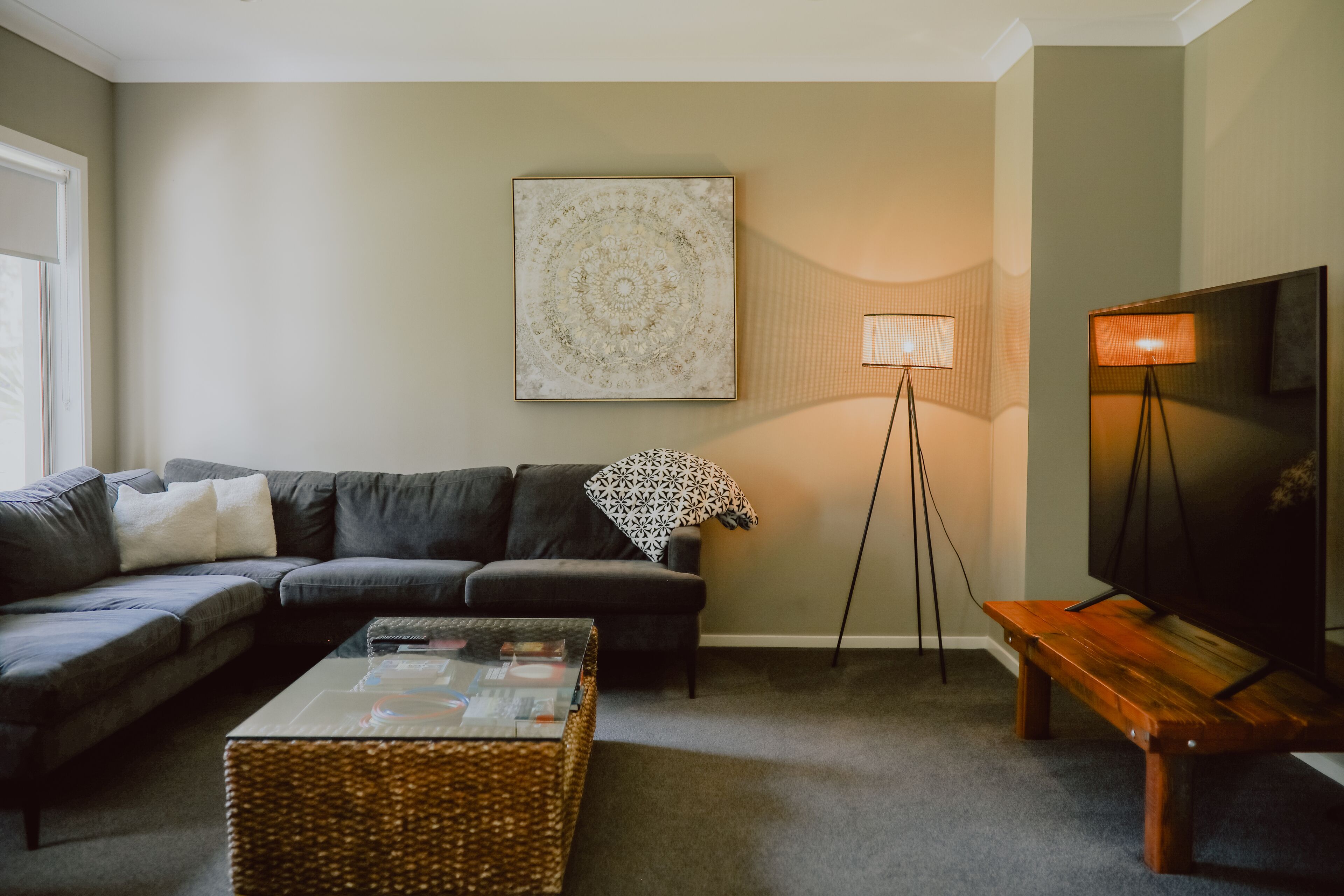 Un salon avec un canapé, une table basse, un lampadaire et un téléviseur.