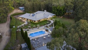 A large house with a swimming pool, surrounded by a well-maintained garden and trees. - Thistle Hill Guest House (Pokolbin)