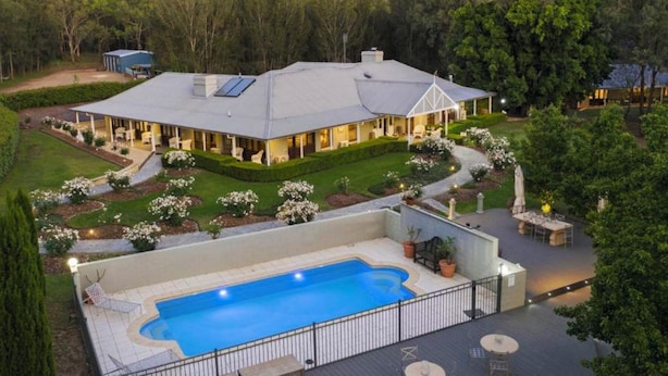 A large house with a swimming pool, surrounded by a well-maintained garden and trees. - Thistle Hill Guest House (Pokolbin)