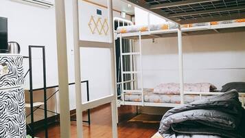 A bunk bed room with a desk and chair, a zebra-patterned cabinet, and a radiator.