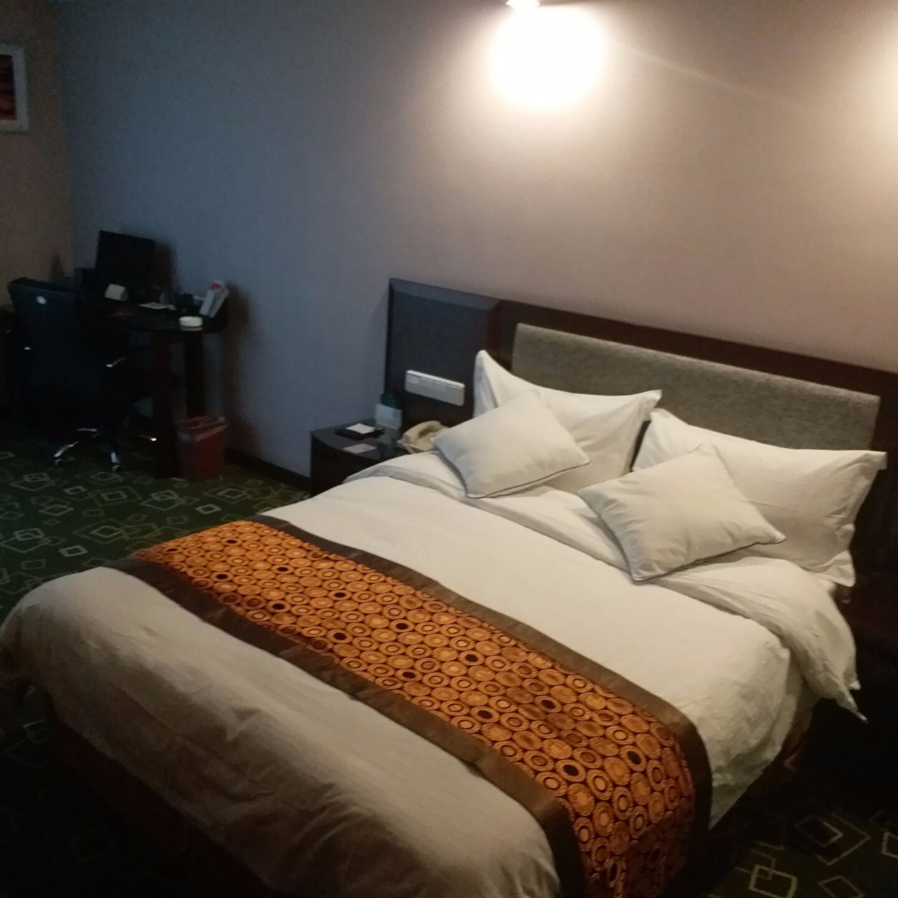 A hotel room with a bed, a desk, and a chair.