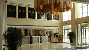 A spacious lobby with a reception desk, large potted plants, and a modern chandelier. - Yinchuan Vintage Hill Hotels & Resorts (Yinchuan)