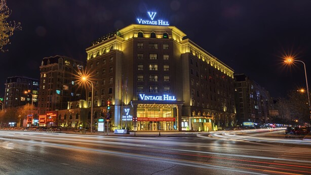 A hotel with a prominent 'Vintage Hill' sign, multiple floors, and a well-lit facade. - Yinchuan Vintage Hill Hotels & Resorts (Yinchuan)