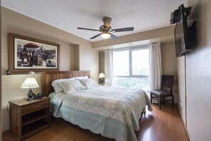 A bedroom with a bed, a nightstand, a chair, a ceiling fan, a window with curtains, and a painting on the wall. - OCEAN VIEW SPECTACULAR & ROMANTIC WALK IN FRONT LARCOMAR/QUEBRADA DE ARMENDARIZ (Miraflores)