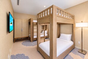 Ein Hotelzimmer mit Etagenbett, einem Kleiderschrank, einem Fernseher und einer Lampe.