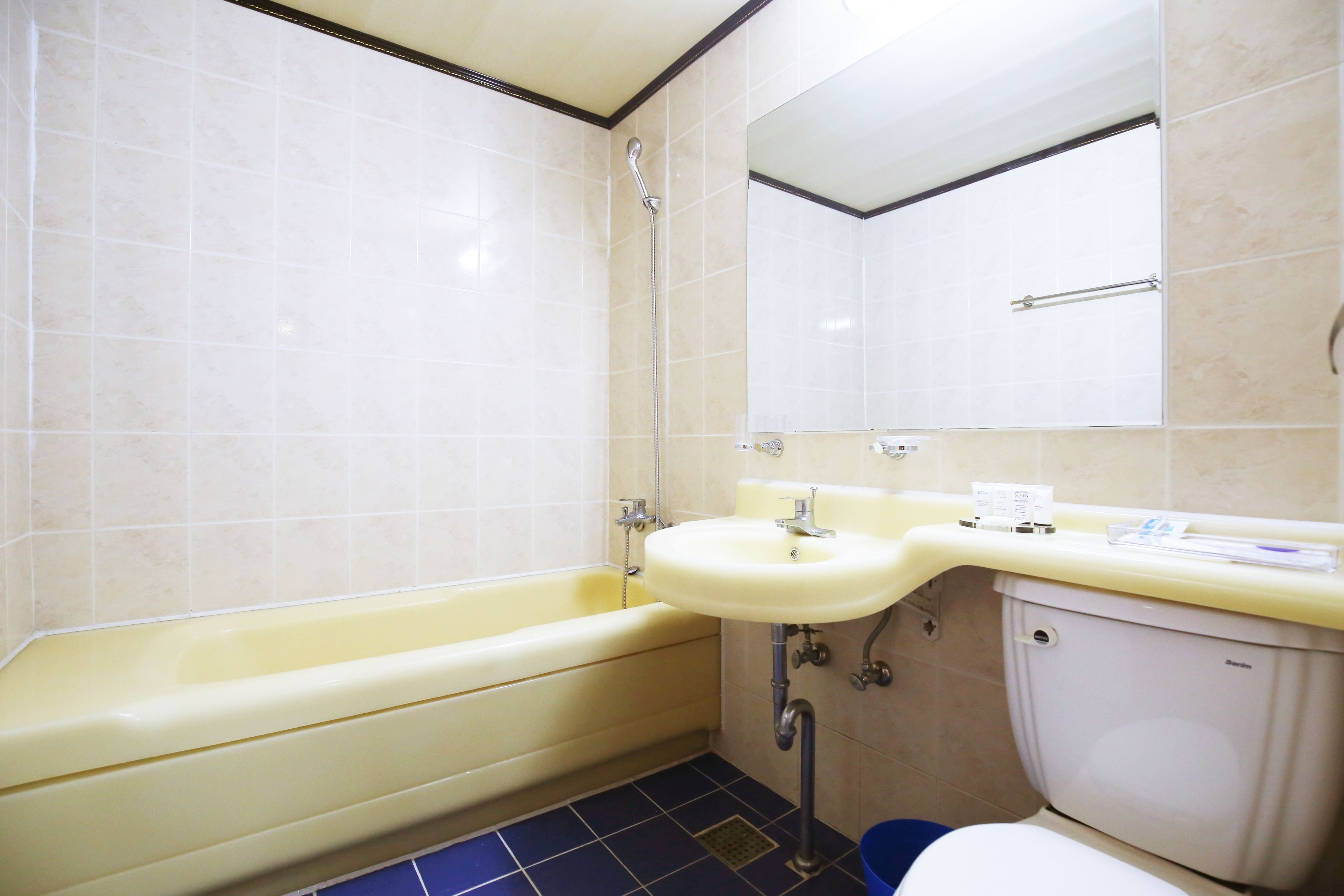 Un baño con bañera, lavamanos, inodoro y espejo.
